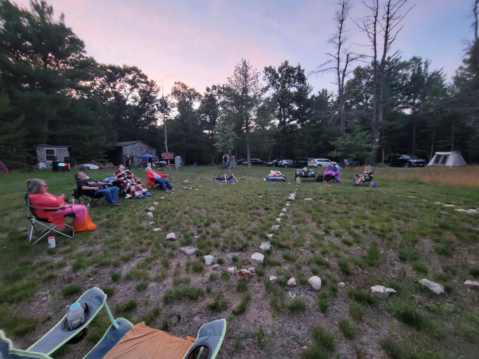 People seated in the field at dusk during Contact Camperoo